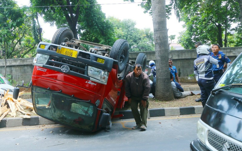 Kaget Ada Motor Nyalip, Supir Truk Banting Stir Hantam Median Jalan Hingga Terguling