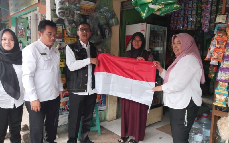 Camat Pamijahan Bagikan Bendera Merah Putih ke Warga