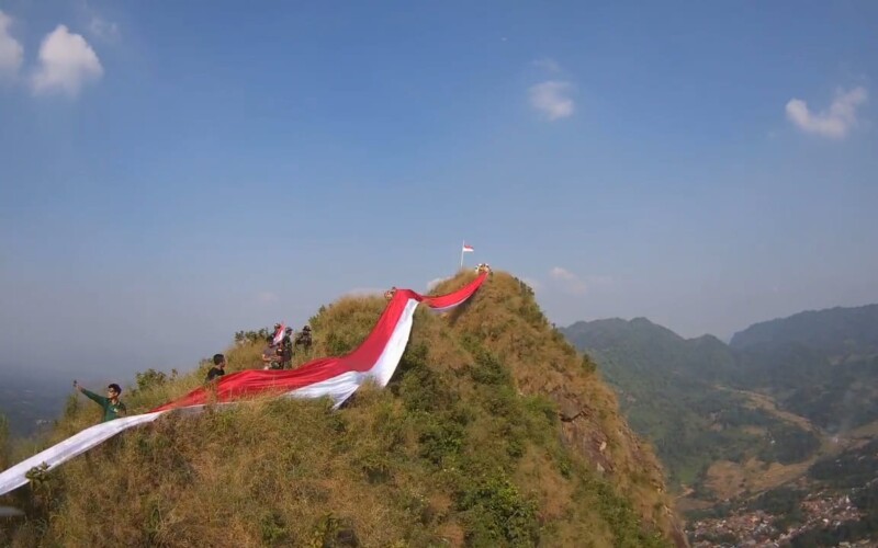 Peringati HUT RI ke – 79 Tahun, Muspika Kecamatan Sukamakmur Bentangkan 100 Meter Bendera Merah Putih di Puncak Gunung Batu
